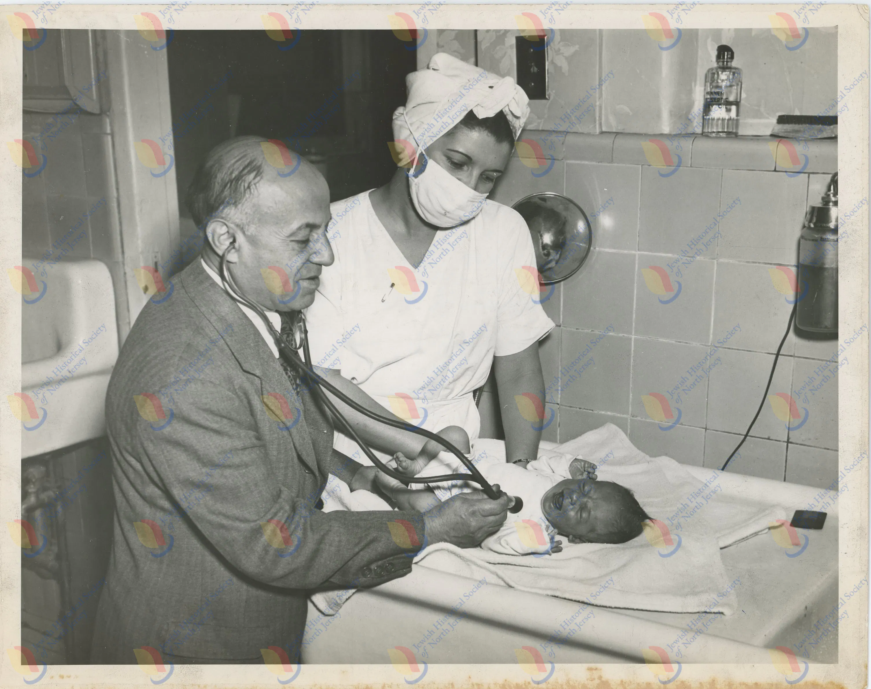 Photo by Simpson Studio - Dr. Morris S. Joelson examining a baby with a nurse.